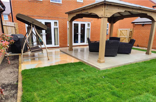 Charming summer house with Kandla Grey sandstone patios, creating a serene outdoor space.